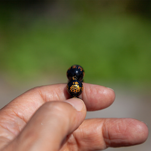 오닉스 원석에 나무아미타불 명호가 금색으로 새겨진 손가락기도단주입니다.